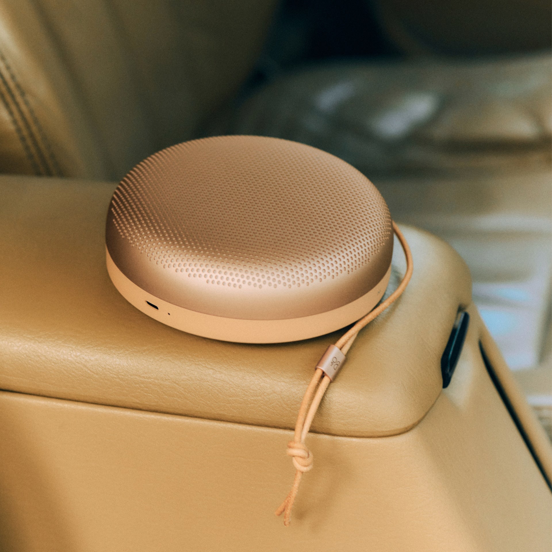 Bang & Olufsen B&O Beosound A1 3. Generation Honey Tone auf der Mittelkonsole eines Autos