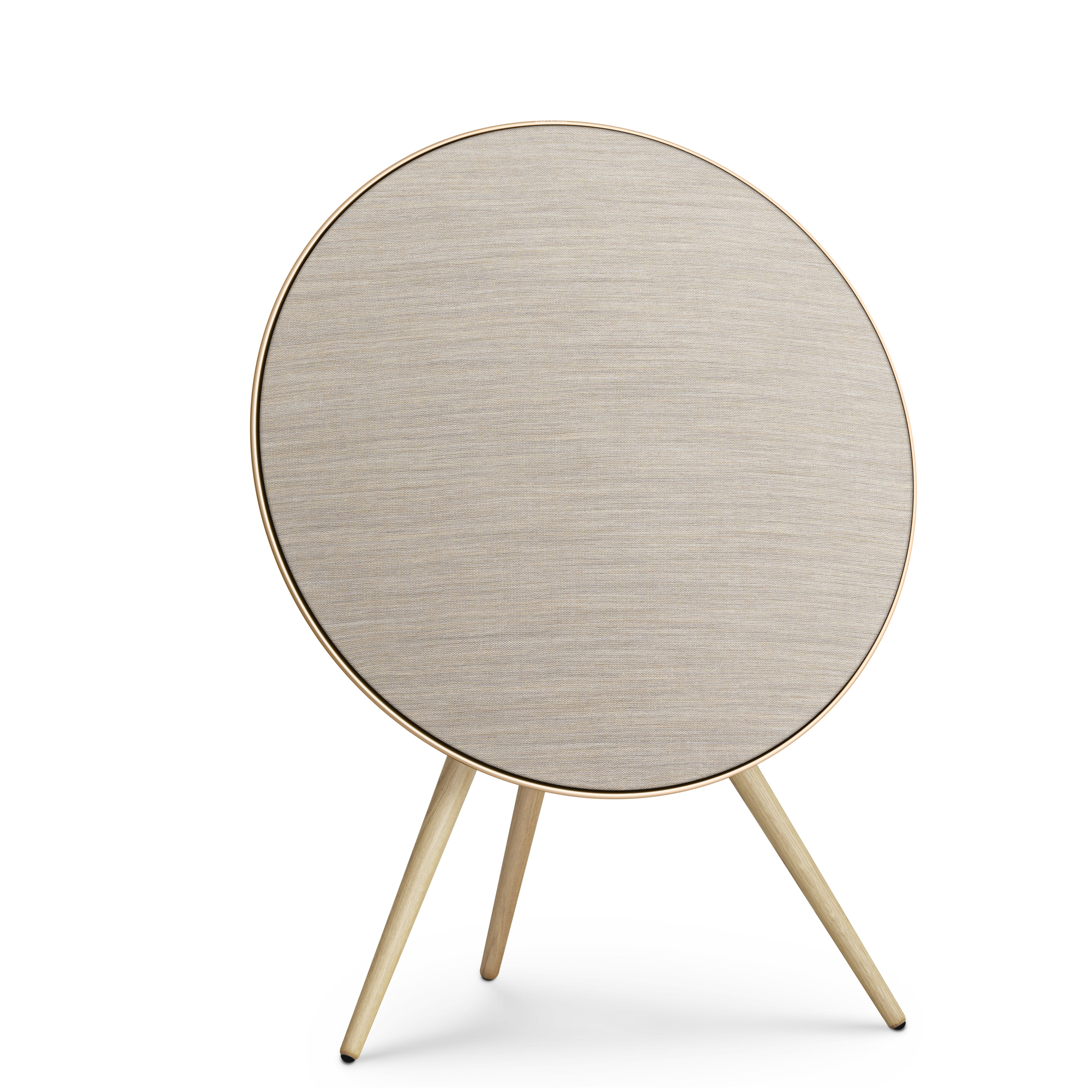 Frontansicht der Beosound A9 in Gold Tone. Das kreisrunde Design mit sandfarbenem Kvadrat-Bezug und hellen Eichenholzbeinen wirkt wie ein zeitloses Kunstobjekt.