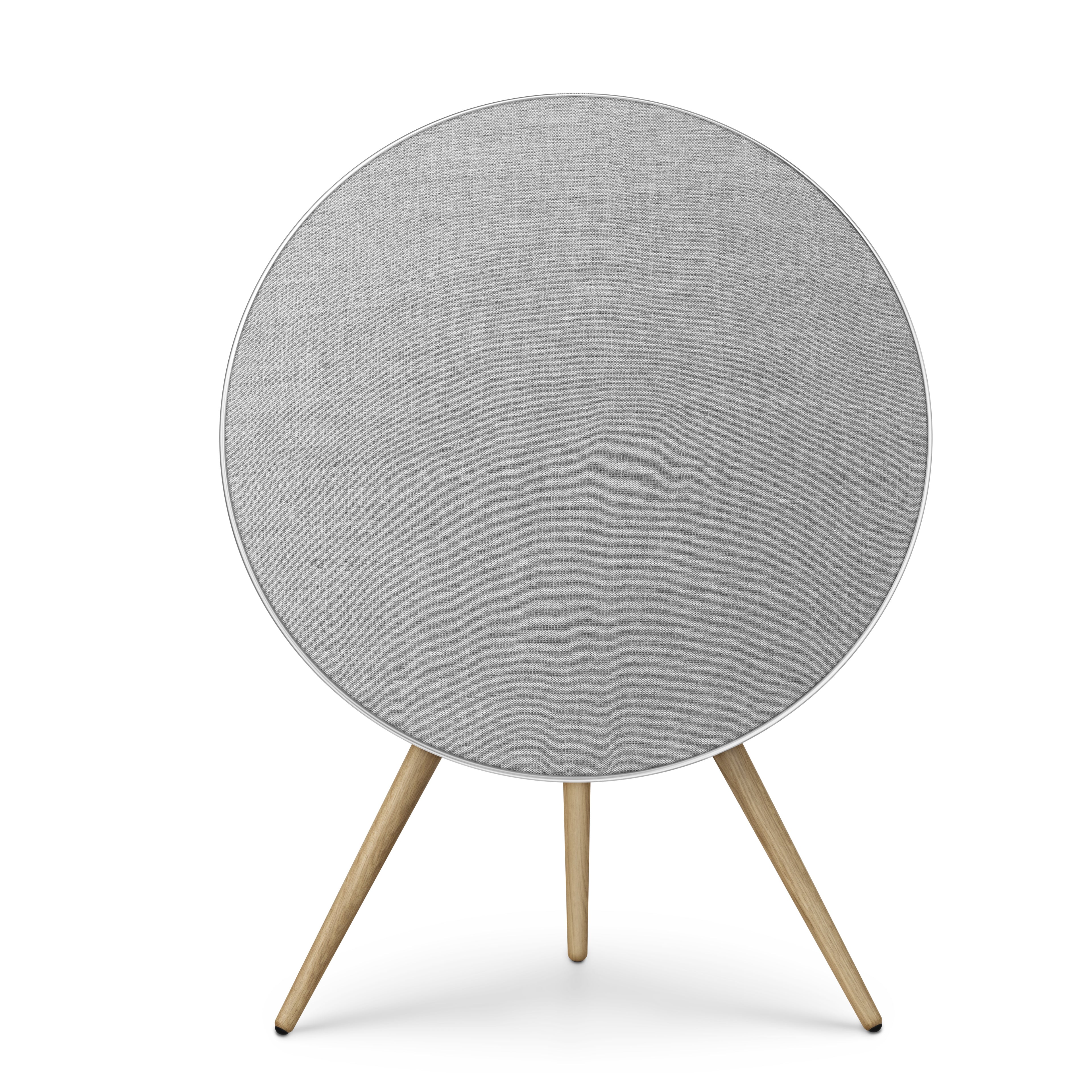 Frontalansicht der Beosound A9 in Natural Aluminium. Der silberne Rahmen umschließt ein lichtgraues Textil-Cover, getragen von Stativbeinen aus heller Eiche. Ein Inbegriff für skandinavisches Design-HiFi.