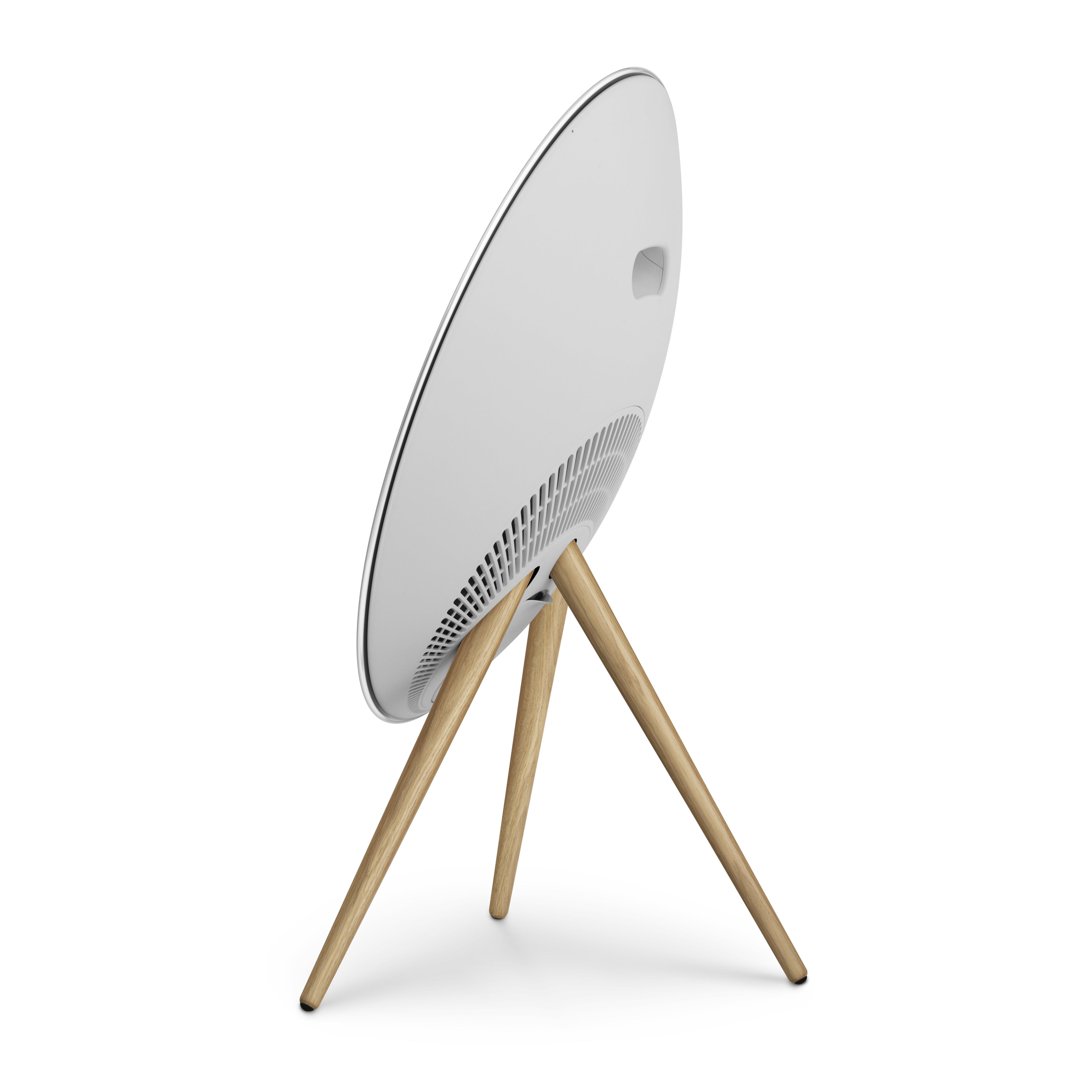 Perspektivische Rückansicht der Beosound A9 (Natural Aluminium). Das weiße, gewölbte Gehäuse und die Stativbeine aus heller Eiche zeigen die skulpturale Qualität des Lautsprechers von hinten.