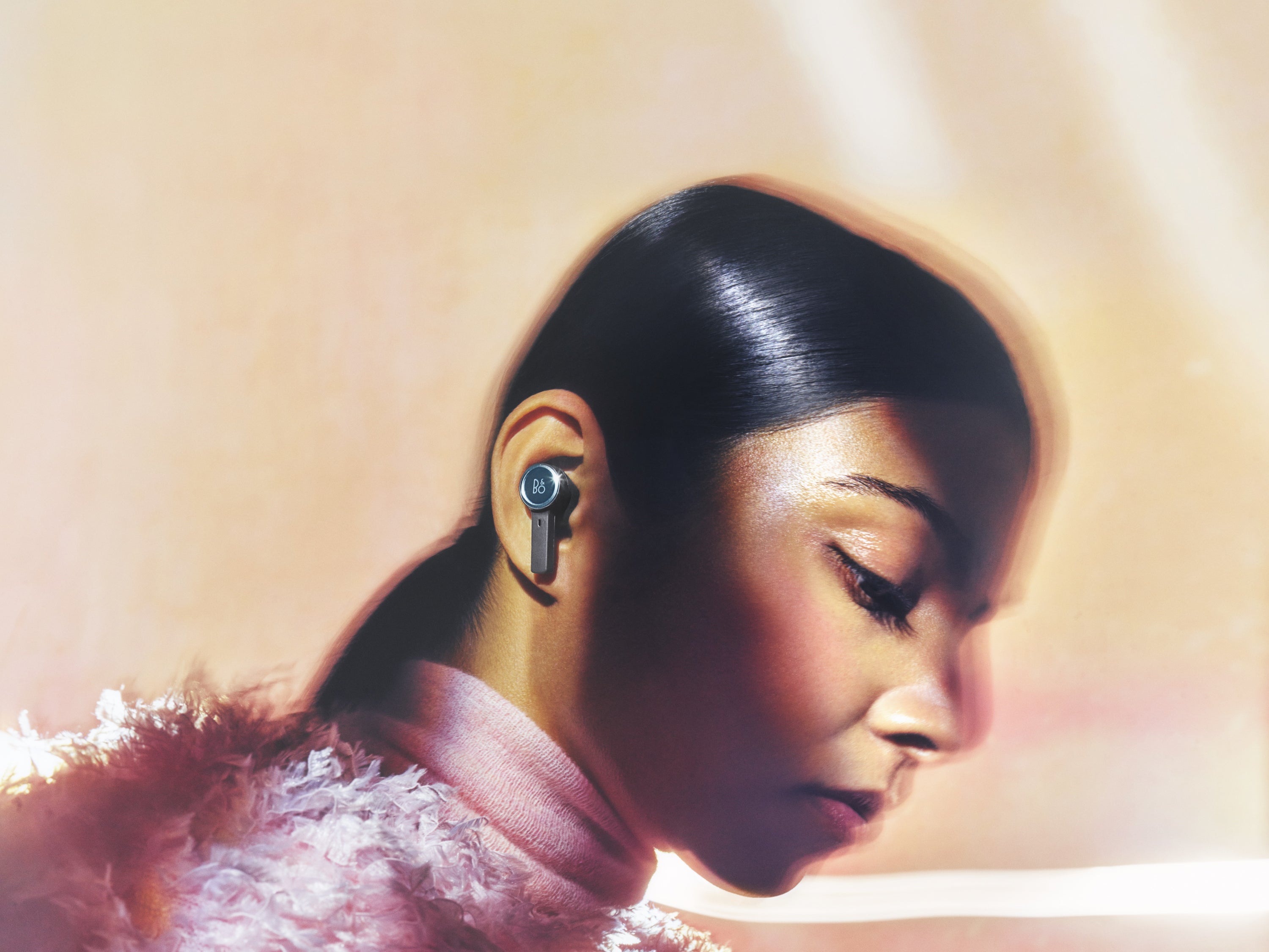 BeoPlay EX-  in der Farbe Anthracite Oxygen im Ohr einer Frau