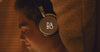 Beoplay H100 Video in schwarz, getragen von einem Mann der Musik genießt und dann einen Anruf bekommt