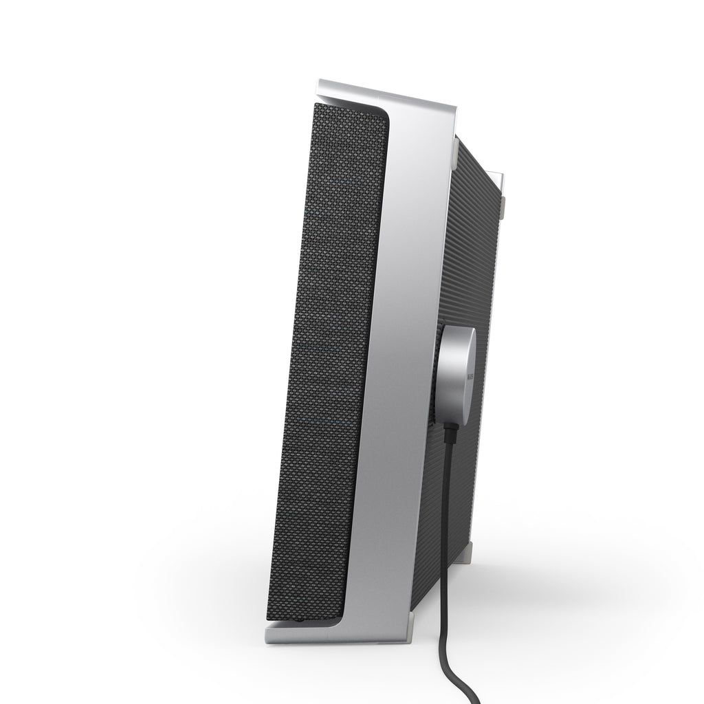 Seitenansicht der Beosound Level im Hochformat. Zu sehen ist der flache Formfaktor und das innovative magnetische Ladekabel, das nahtlos an der Rückseite des Aluminiumrahmens andockt.