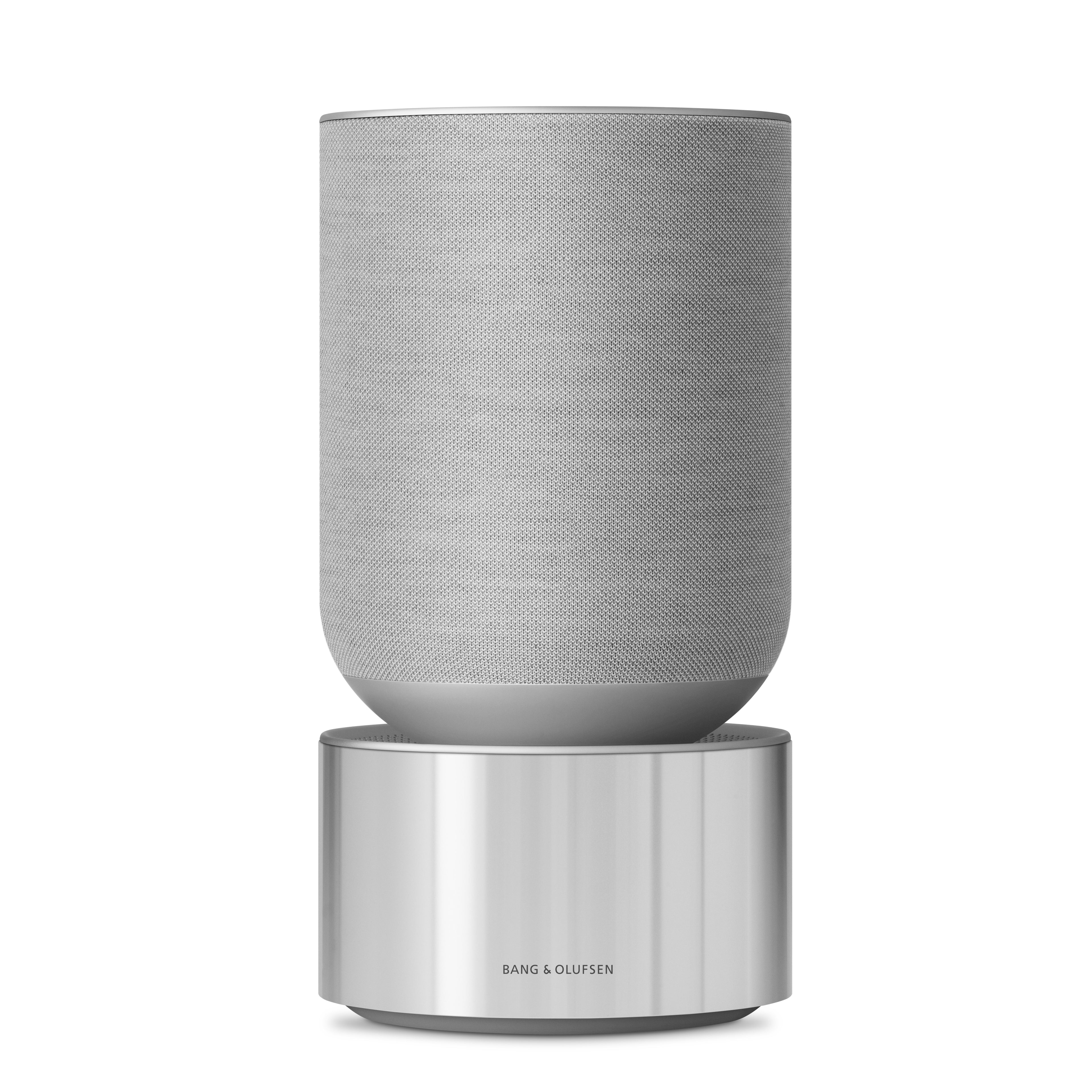Bang & Olufsen Beosound Balance Heimlautsprecher in Natural Aluminium. Die Ansicht zeigt die zylindrische Basis aus silbernem Aluminium mit B&O-Gravur und den oberen Teil mit grauem Kvadrat-Textilbezug vor weißem Hintergrund.